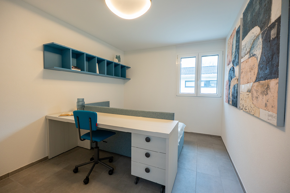 Camera da letto singola con scrivania e architettura delle case a schiera in affitto a Moleno.