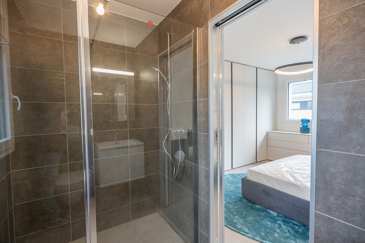 Camera da letto, zona doccia e architettura delle case a schiera in affitto a Moleno.